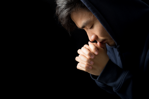 Praying man hoping for better. Asking God for good luck, success, forgiveness. Power of religion, belief, worship. Holding hands in prayer, eyes closed.