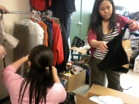 (photo: Gene-Mar Galasinao and Cathy Besarra sort and fold clothes at the Thrift Store)